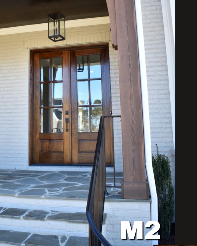 M2 mahogany double entry door with divided lite glass, on a white brick home with a stone walk