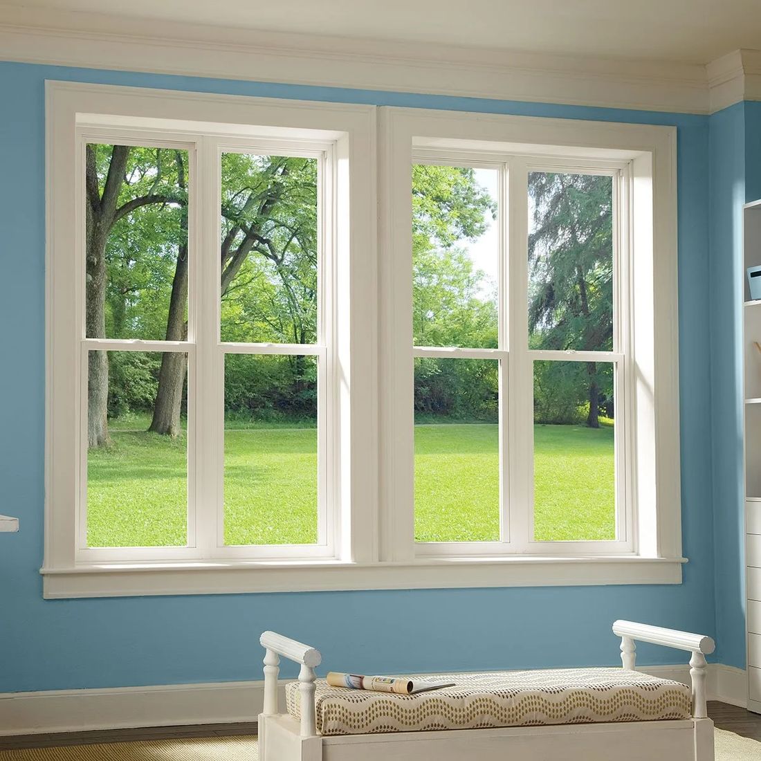 Atrium side-load single hung windows installed in a bright room with a window seat